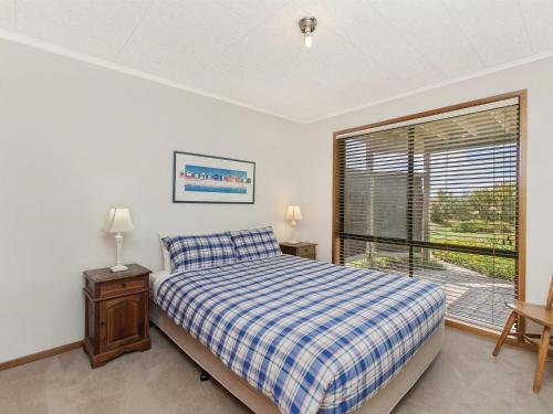 sypialnia z łóżkiem i oknem w obiekcie Waters Edge w mieście Port Fairy