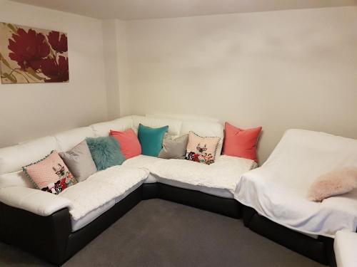 a white couch with colorful pillows on it at Liverpool Anfield in Liverpool