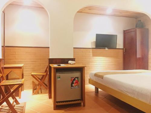 a bedroom with a bed and a tv in it at Sầm Sơn Boutique Hotel Phan Thiết in Phan Thiet