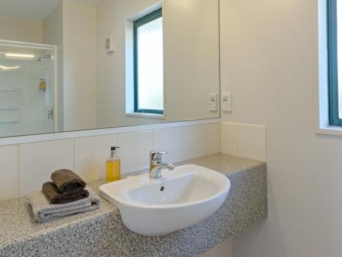 ein Badezimmer mit einem weißen Waschbecken und einem Spiegel in der Unterkunft Bella Vista Hanmer Springs in Hanmer Springs