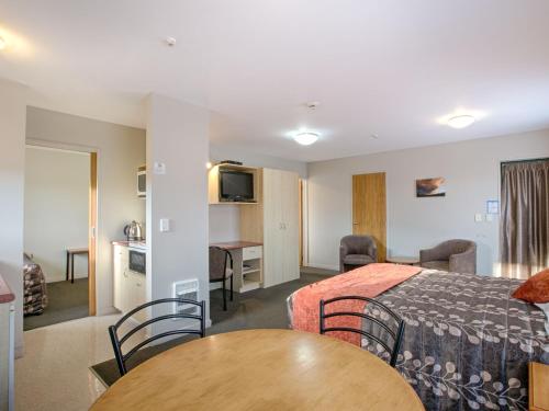 a hotel room with a bed and a table at Bella Vista Hanmer Springs in Hanmer Springs