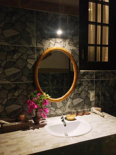 a bathroom with a sink and a mirror at Sầm Sơn Boutique Hotel Phan Thiết in Phan Thiet
