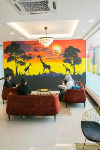 a lobby with a mural of giraffes on the wall at Savana Hotel & Serviced Apartments in Kuala Perlis