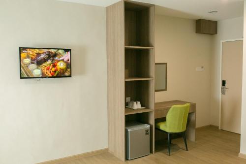 a room with a desk and a green chair at Savana Hotel & Serviced Apartments in Kuala Perlis