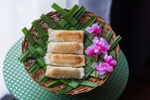 a plate of food withsticks and green beans and pink flowers at Sayong Resort in Kuala Kangsar