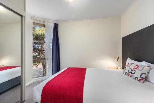 a bedroom with a large bed and a window at Knox International Hotel and Apartments in Wantirna