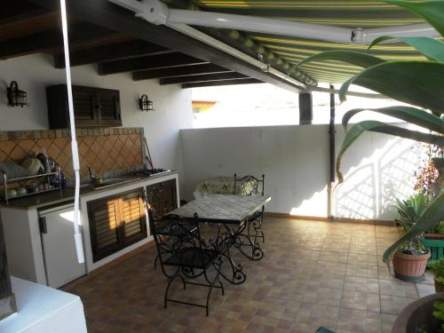a patio with a table and chairs in a kitchen at Case Vacanze Albamarina in Lipari