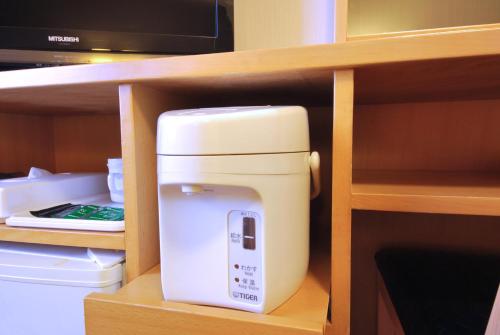 a white appliance on a shelf in a kitchen at Hotel Route-Inn Morioka Ekimae in Morioka