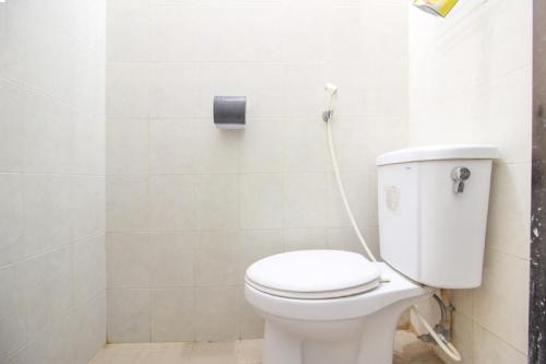 a bathroom with a toilet with a hose at Reddoorz Syariah near Wijilan Yogyakarta in Yogyakarta