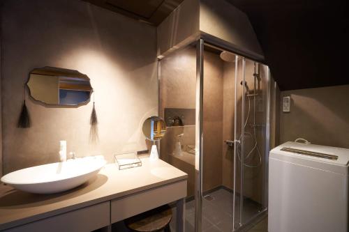 a bathroom with a sink and a shower at Bed and Craft MITU in Nanto