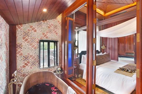 クレンにあるAksorn Rayong, The Vitality Collection - SHA PLUSの寝室のある部屋にバスタブがある