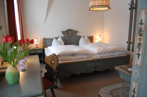 a bedroom with a bed with white sheets and a table at Landgasthof "Am Park" in Crottendorf
