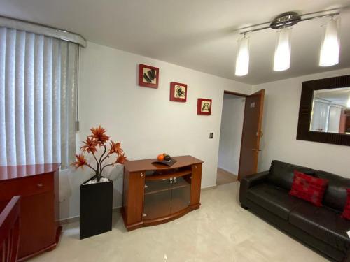 a living room with a couch and a table at Condominio Renoir in Mexico City