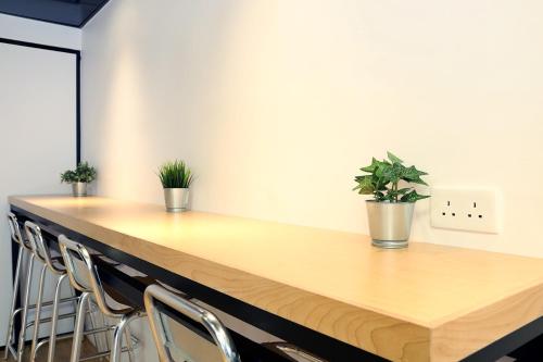 a wooden counter with chairs and plants on it at Bluejay Residences in Hong Kong