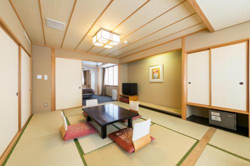 a living room with a table and chairs at Tateshina Grand Hotel Takinoyu in Chino