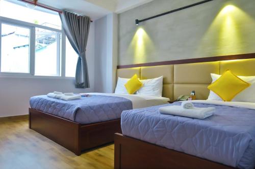 une chambre avec deux lits et une fenêtre dans l'établissement Giang Sơn Hotel 江山民宿范五老街胡志明市, à Hô-Chi-Minh-Ville