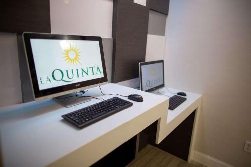 a desk with a computer monitor and a laptop on it at La Quinta by Wyndham Houston East at Normandy in Houston