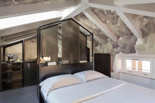 ein Schlafzimmer mit einem großen weißen Bett in einem Zimmer in der Unterkunft Casa Trentini - Atemporary Art Apartments in Trient