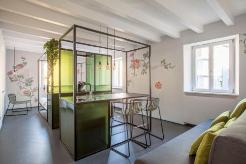 un soggiorno con cucina completa di bar e sedie di Casa Trentini - Atemporary Art Apartments a Trento