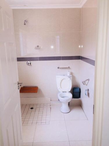a bathroom with a white toilet in a stall at Royal Ushaka in Durban
