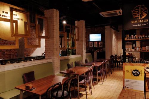 a restaurant with wooden tables and chairs and a bar at Kim Haus Loft in George Town