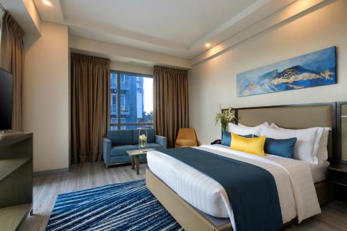 um quarto de hotel com uma cama e uma TV em Savoy Hotel Mactan em Mactan