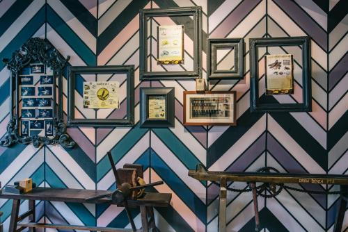 a wall with many framed pictures on a wall at Kim Haus Loft in George Town