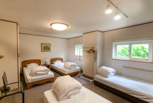 um quarto com duas camas e uma janela em Niseko Ski Lodge - Higashiyama em Niseko