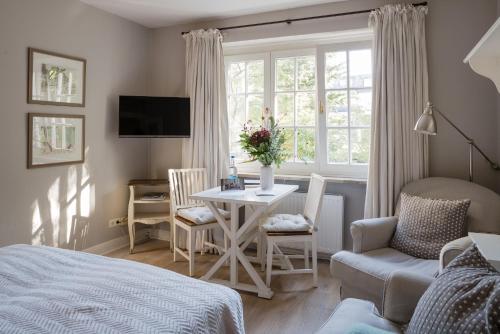 a bedroom with a bed and a table and a window at von Deska Townhouses - Ivy House in Hamburg