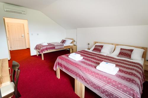 - une chambre avec 2 lits et un tapis rouge dans l'établissement Venclův statek, à Javornice