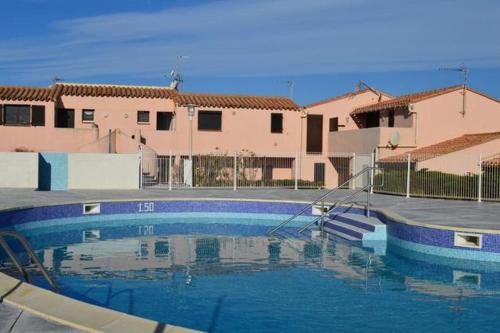 a swimming pool in front of a building at Résidence naturiste Aphrodite appartement 940 in Leucate