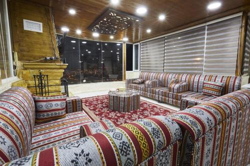 a living room with couches and a large window at Basant Villa in Wadi Musa