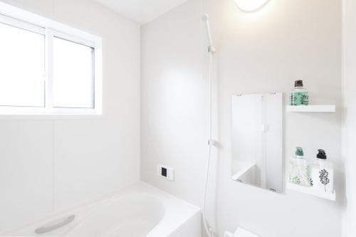 a white bathroom with a sink and a mirror at Villas Fujiyoshida in Fujiyoshida