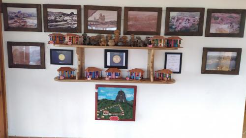 a wall with a shelf with miniature houses on it at Hotel Zocalo Campestre in Guatapé