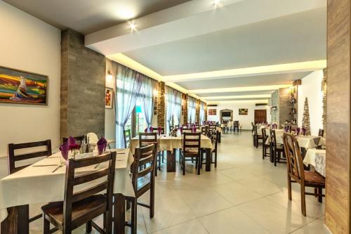 a dining room with tables and chairs in a restaurant at Family Hotel BOHEMA in Ognyanovo