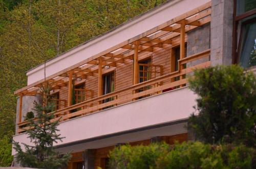 a house with a wooden balcony on the side of it at Family Hotel BOHEMA in Ognyanovo