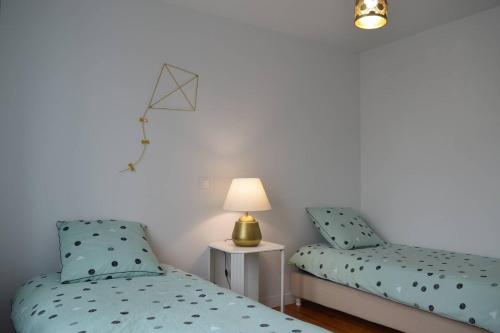 - 2 lits jumeaux dans une chambre avec une lampe sur une table dans l'établissement VILLA KEREZAM au petit port de Mogueriec, à Sibiril