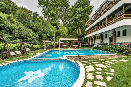 a swimming pool in a yard next to a building at Family Hotel BOHEMA in Ognyanovo