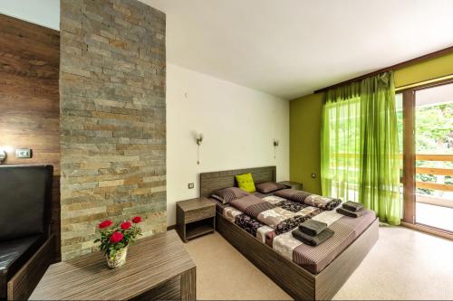 a bedroom with a bed and a couch at Family Hotel BOHEMA in Ognyanovo