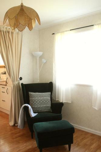 a living room with a chair and a window at Grönelid Gård in Tived