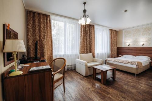 ソルネチノゴルスクにあるLESNOY Park Hotelのベッドとデスクが備わるホテルルームです。