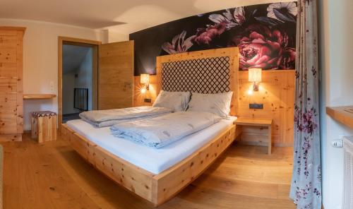 a bedroom with a bed with a wooden headboard at SpieljochLodge in Fügen