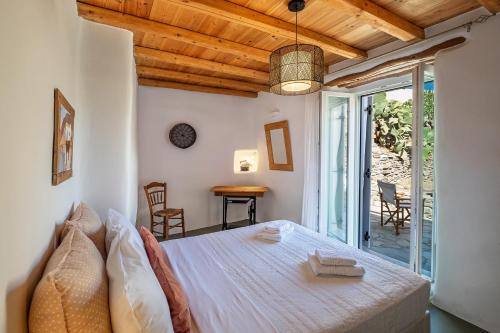 a bedroom with a bed and a table and chairs at Exochi Traditional Houses in Krotiri
