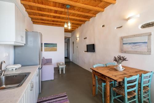 a kitchen and dining room with a wooden table and chairs at Exochi Traditional Houses in Krotiri