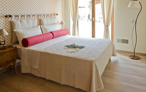 Monte San PietrangeliにあるAgriturismo La Perlaのベッドルーム1室(大型ベッド1台、赤と白の枕付)