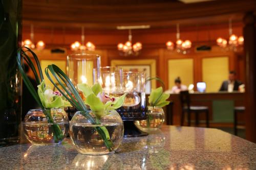 un tavolo con tre vasi con fiori di Charterhouse Causeway Bay a Hong Kong