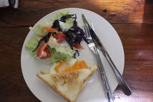 a plate of food with a salad and a sandwich at Pai Modern House in Pai
