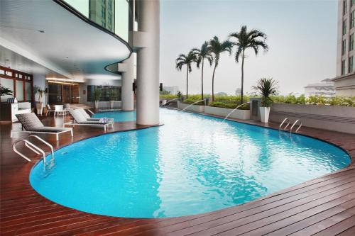 a large swimming pool in a building with palm trees at Dorsett Kuala Lumpur in Kuala Lumpur