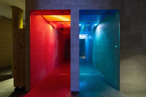 un couloir avec des lumières rouges et bleues dans une chambre dans l'établissement Resort Mark Brandenburg & Fontane Therme, à Neuruppin