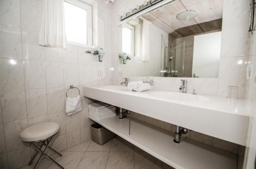 a white bathroom with a sink and a mirror at Apartments Blaickner in Neukirchen am Großvenediger